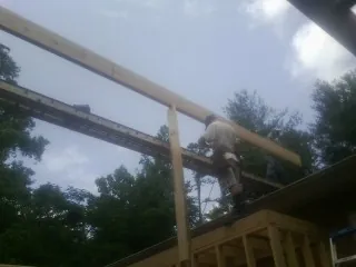Carpenter setting a ridge beam over a new addition frame — Ice Dam Removal by Roofing Brothers in Crivitz
