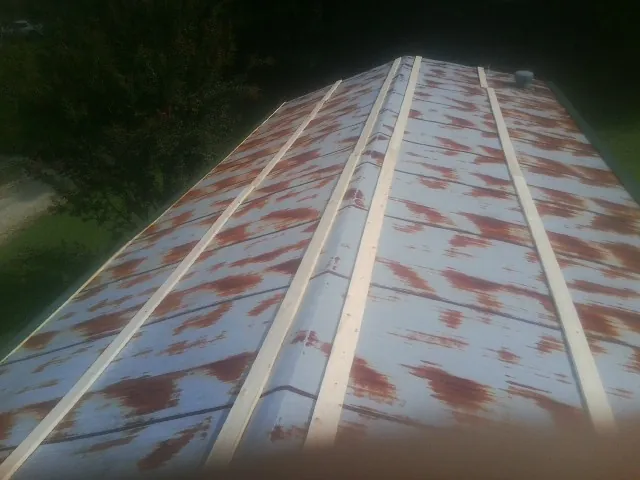 Rusted metal roof panels with new wood purlins before replacement — Storm Damage Roof Repair in Crivitz by Roofing Brothers