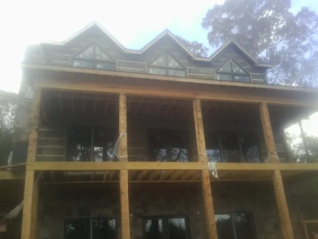 Dormers and porch framing on a large log home under construction — Roof Coating work by our crew in Crivitz