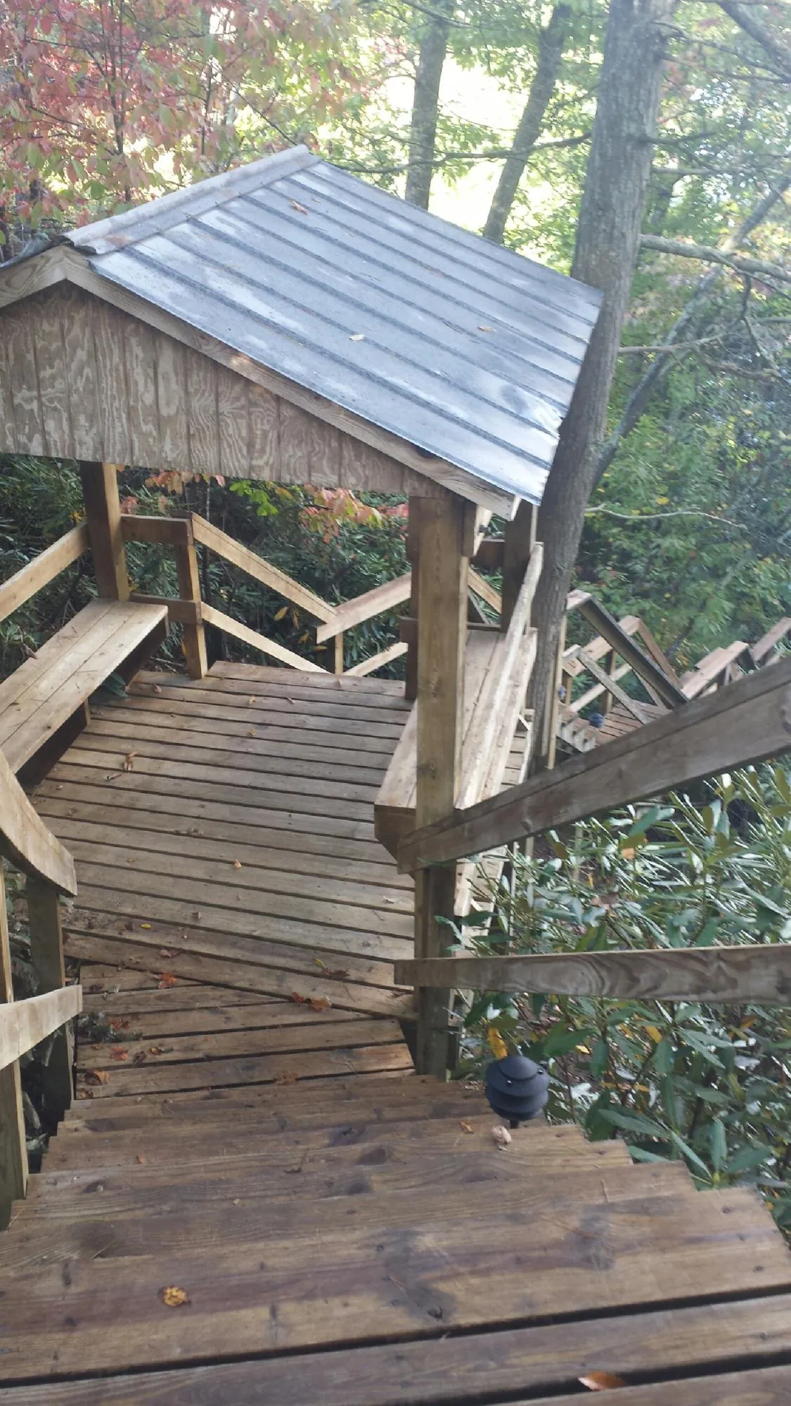 Metal roofed shelter over wooden steps on a wooded walkway — Skylight Repair & Installation work by our crew in Crivitz